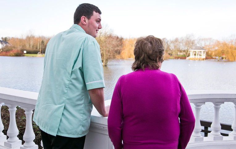 resident and carer looking over lake