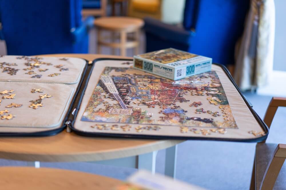 Table with an open puzzle box and a partially completed puzzle.