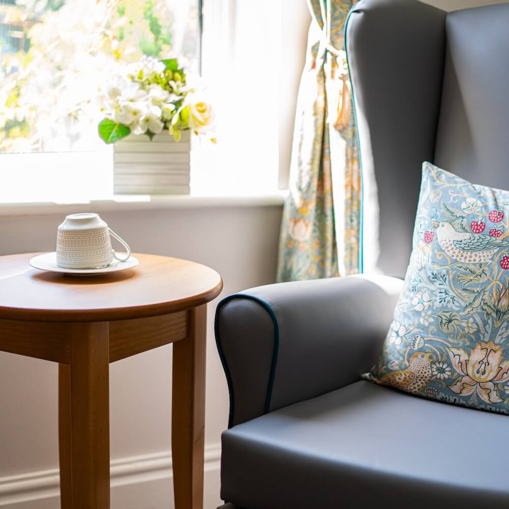 Armchair with a cushion and a side table.